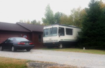 Motorhome Parked in front of a house with a toyota camery